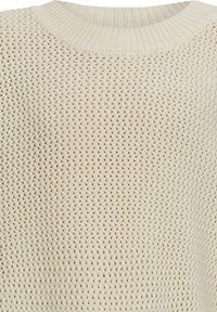 Strickpullover in Off-White mit strukturiertem Muster, ausgestattet mit einem gerippten Ausschnitt und einem offenen Strickmuster, das das weiche Material und das lässige Design betont.