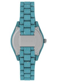 Montre Timex avec un bracelet en caoutchouc texturé turquoise, dotée d'un fond en acier inoxydable et d'un boîtier rectangulaire avec une boucle simple.