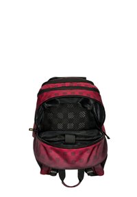 Zaino rosso e nero con un motivo geometrico, dotato di un comparto principale con zip e una cintura sicura per i dispositivi all'interno.