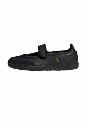 Chaussure Adidas Samba noire avec bride Velcro, trois bandes latérales et semelle texturée, vue de profil sur fond blanc.