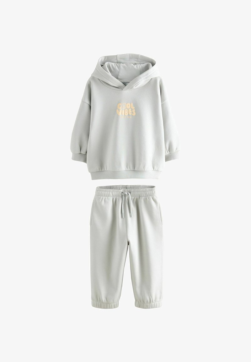 Hellgraues Sweatshirt- und Jogginghosen-Set aus weichem Material. Das Sweatshirt hat eine Kapuze und bedruckten Text; die Hose hat einen elastischen Bund und Bündchen.