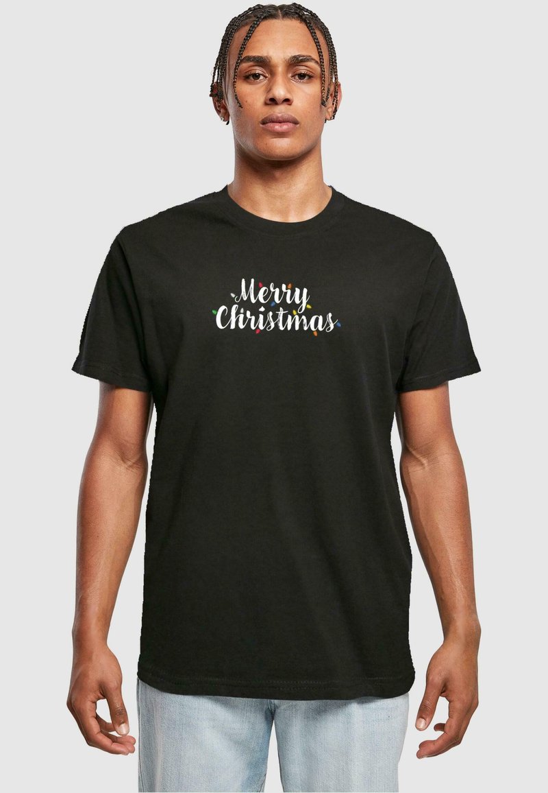 Black cotton t-shirt featuring "Merry Christmas" text in white with colorful accents. Short sleeves, crew neck, relaxed fit, casual design.