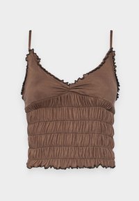 Brown cropped top made of soft fabric, featuring a shirred design, adjustable straps, and ruffled edges with black accents.