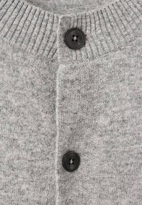 Primer plano de un cárdigan de punto gris con cuello acanalado, que presenta dos botones negros y una textura suave. Color uniforme con un sutil patrón jaspeado.