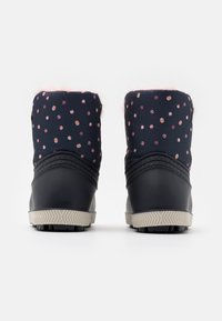 Bottes cheville imperméables avec une tige en tissu bleu marine parsemée de rose, semelle en caoutchouc noir, et une doublure en fausse fourrure rose douce au sommet.