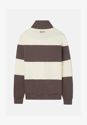 Suéter a rayas marrón y crema con cuello, con un borde inferior de color marrón oscuro. Textura suave, con un branding mínimo en el cuello.