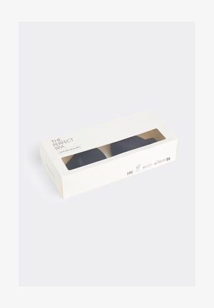 Hvid rektangulær æske med et transparent vindue, der viser en sort bh indeni mærket "The Perfect Bra" af Intimissimi.