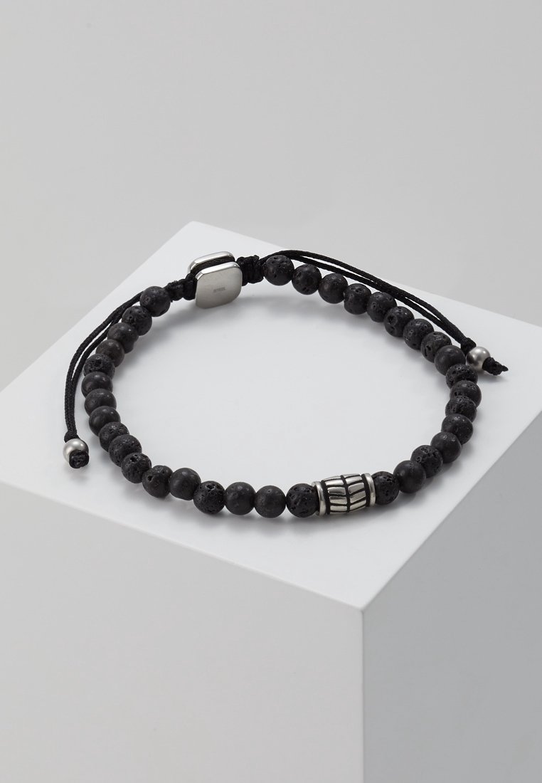 Bracelet réglable noir à perles rondes texturées, une perle décorative argentée en forme de barillet, et des embouts de corde noirs avec petites perles argentées.