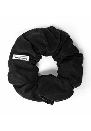 Czarna gumka do włosów z tkaniny o fakturowanym wykończeniu, z małą białą metką z napisem "SURF" i wzorem fali. Okrągły kształt, elastyczny materiał.