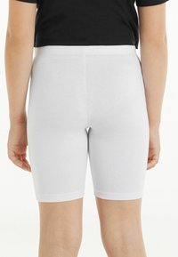 Pantaloni corti in misto cotone bianchi con vita elastica, che arrivano a metà coscia, texture liscia e design aderente.
