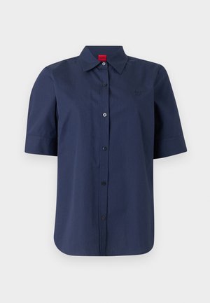 Camisa de manga corta azul marino con botones y cuello, con un logo sutil en el pecho de la marca Hugo.
