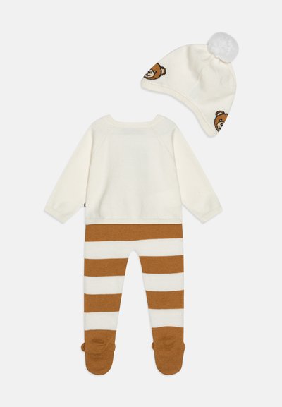 Completo per neonati lavorato a maglia in crema con leggings a righe marroni e un cappellino coordinato con design di orsetto e pompon in cima.