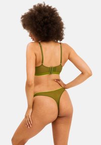 Olijf groene sheer lingerie set, bestaande uit een bh met verstelbare straps en een bijpassende string, met een gladde textuur en minimalistisch ontwerp.