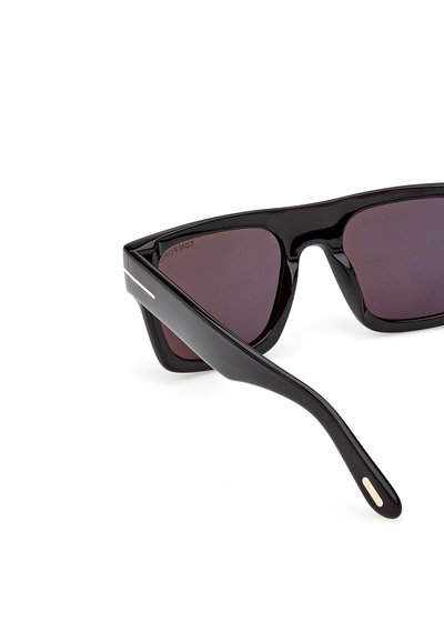 Gafas de sol rectangulares negras con montura gruesa y brillante y lentes tintadas oscuras, mostradas en ángulo sobre un fondo blanco.