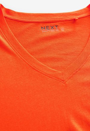 Oranges Baumwoll-V-Ausschnitt-T-Shirt mit glatter Textur und sauberer Naht entlang des Halsausschnitts und Saums. Logo-Tag sichtbar.
