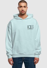 Light blue oversized hoodie made of soft fabric, featuring a front pouch pocket and black "ICE CREAM" graphic with a popsicle design.