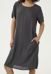 Harmaa pellava-mekko, jossa on lyhyet hihat, syvä kaula-aukko, sivutaskut ja suora leikkaus, jossa on polvimittainen helma ja hienovarainen tekstuuri.