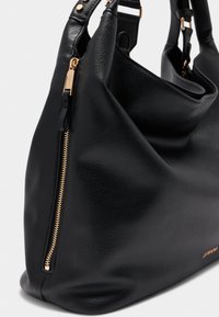 Sac à main en cuir noir avec une surface texturée, doté d'une fermeture éclair dorée et de quincaillerie, d'une forme décontractée et de deux poignées pour l'épaule.