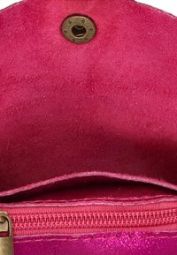 Monedero de ante rosa con cierre de cremallera y botón de pressão de bronce. Interior suave con una superficie texturizada, realzada por detalles de costura.