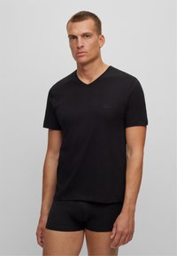 Black cotton V-neck t-shirt with short sleeves, featuring a subtle logo on the chest. Worn with matching black boxer briefs.