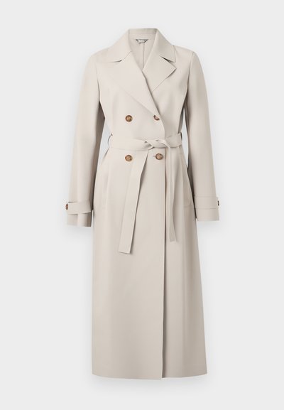 Lungo trench coat doppiopetto beige con ampi revers, bottoni marroni, cintura annodata in vita e cinturini con bottoni ai polsini.