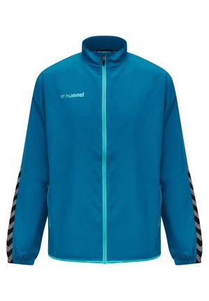Hummel jas in een levendige blauwe kleur met een hoge kraag en volledige rits. Heeft een zwart en grijs chevron patroon op de mouwen, elastische manchetten en zijzakken.