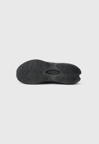 Mustakummist jalanõu tallaga tekstuursete tallalaudadega ja keskel "Clarks" logo, valge tausta peal.