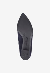 Zapato de mujer de ante marino con diseño de punta afilada, bajo tacón de goma negra y logotipo de la marca grabado en la suela. Textura suave y líneas limpias.