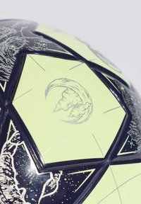 Crna i neonska zelena nogometna lopta s heksagonalnim panelima, složenim lunarnim i kozmičkim uzorcima te sjajnom teksturom.