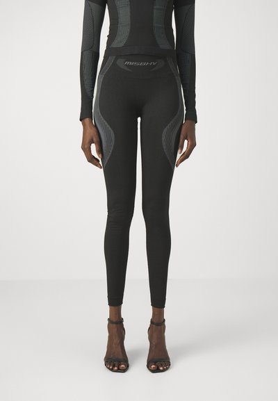 Leggings negros con un diseño ajustado, que presentan acentos grises contrastantes y patrones texturizados a lo largo de los lados. Tela suave, de longitud hasta el tobillo.