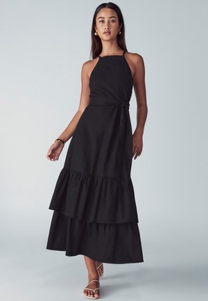 Schwarzes Maxikleid mit Halterneck, tailliertem Schnitt mit Gürtel und geschichtetem Volant-Saum. Weicher Stoff mit einfarbigem Design.