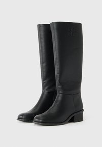 Botas de couro pretas até ao joelho com uma superfície ligeiramente texturizada, salto bloco baixo e logótipo "DKNY" em relevo no lado exterior.