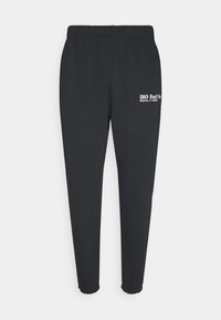 Czarne spodnie dresowe z elastycznym paskiem w talii, zwężanymi nogawkami i białym logo z napisem po lewej stronie, wykonane z miękkiego, trwałego materiału.