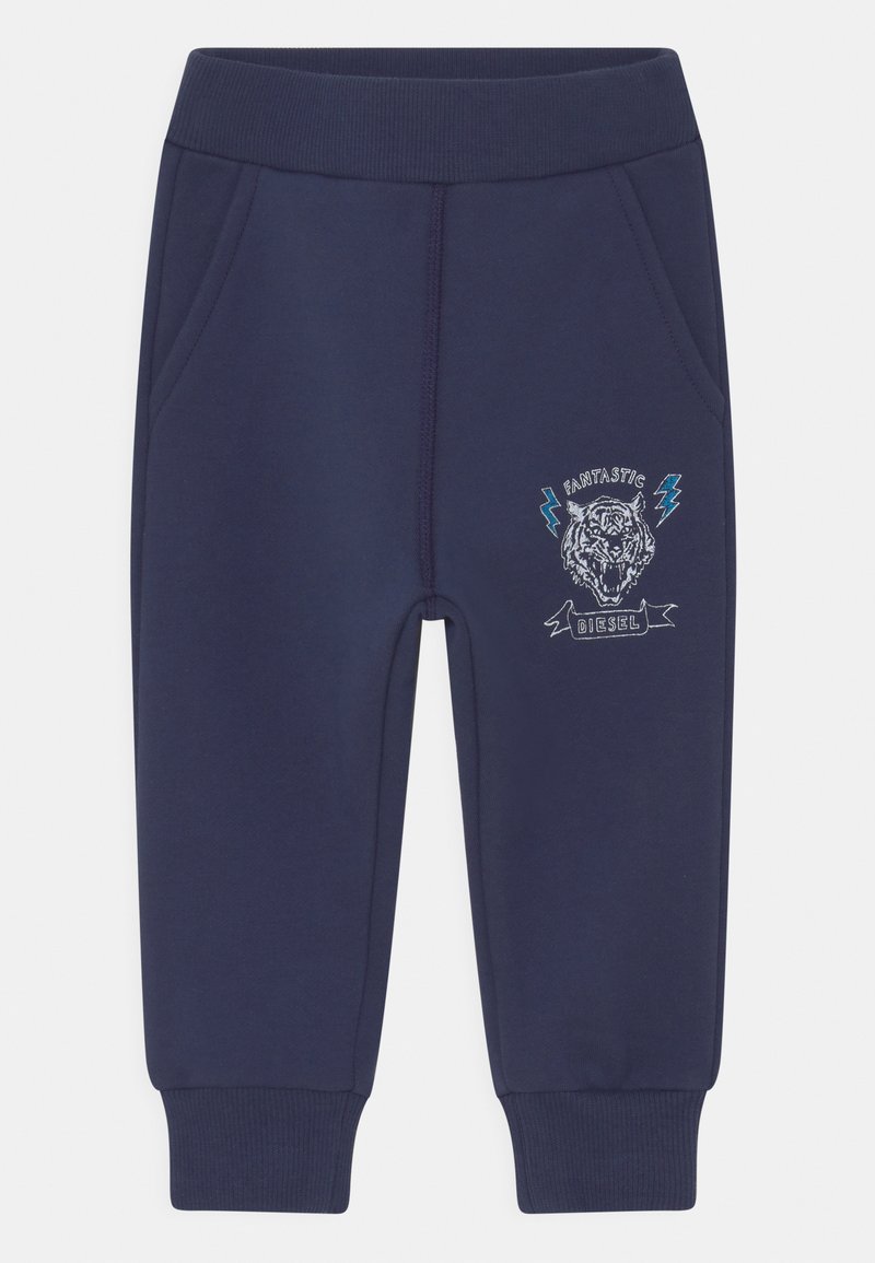 Calças de jogging azul-marinho feitas de um tecido suave, com bolsos laterais e um design de tigre bordado com detalhes de relâmpagos na frente.