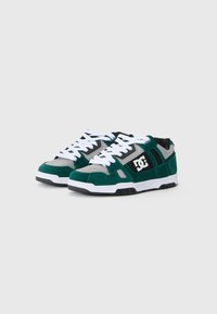 Grüne und graue Wildledersneaker mit weißen Schnürsenkeln, schwarzen Akzenten, gepolstertem Zungenbereich und Logodetail an der Seite. Gummisohle für guten Halt.