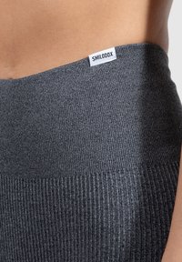 Grå ribbad tygmidja med en liten vit etikett med "SMILODOX." Nära vy av textur och färgdetaljer.