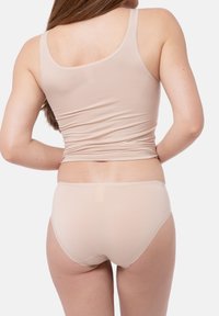 Beige linne och korta underkläder set, tillverkat av mjukt och elastiskt material, med en åtsittande design och minimala sömmar för komfort.