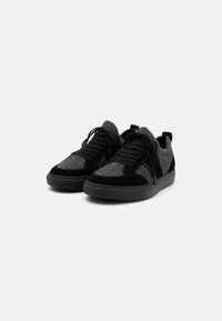 Fekete és szürke sneaker, filc és velúr felsőrésszel, kerek orral, lapos fűzőkkel és texturált gumitalppal.