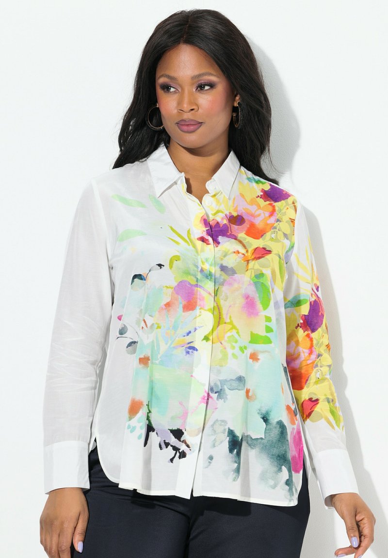 Blusa bianca con bottoni, caratterizzata da una stampa floreale acquerello colorata sul lato sinistro, con una vestibilità ampia e maniche lunghe.