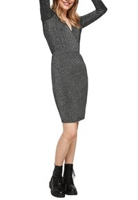 Svart och silver glittrande långärmad klänning med V-hals, figursydd form, knälång, i kombination med svarta snörda kängor.