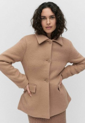 Veste en mélange de laine beige avec un col, trois boutons et des poches latérales. Texture douce, coupe ajustée et ourlet incurvé.