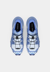 Μπλε αθλητικά παπούτσια με υφασμένο επάνω μέρος από πλέγμα, ζιγκ-ζαγκ σχέδια, προσαρμοστικό σύστημα κορδονιών και ανθεκτικές σόλες για πρόσφυση.