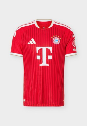 Czerwona koszulka piłkarska FC Bayern Monachium z białymi logo Adidas i Telekom, złotym obramowaniem na kołnierzu i rękawach oraz naszywką Allianz na prawym rękawie.