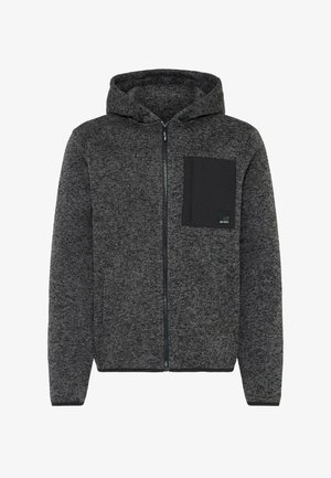 Pilkos spalvos užtrauktuku užsegamas megztinis su tekstūruotu audiniu, drabužių užtrauktuku kapulė. Krepšys juodai nugarėlėje. Yra šoninės kišenės ir raukšlėtos rankovės.