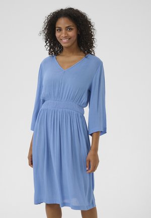 Blue dress with a V-neck, long sleeves, and a smocked waist. Made of lightweight fabric with a loose fit, falling to mid-calf length.