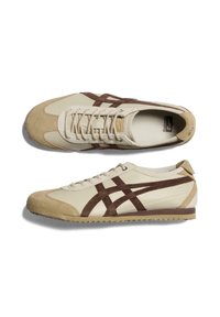 Sneaker beige con accenti in suede e pelle marrone, punta rotonda, lacci piatti e suola in gomma testurizzata con battistrada a motivo.