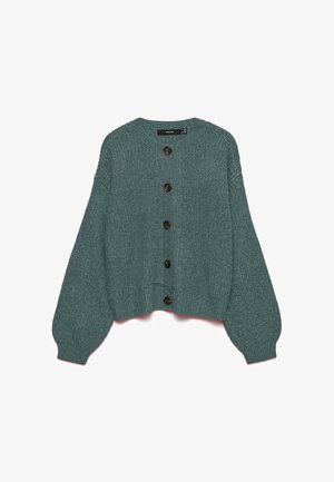 Mėlynos spalvos megztinis su apvalia iškirpte, ribotais rankogaliais ir didelėmis rankovėmis. Priekyje yra šeši dideli rudi mygtukai.