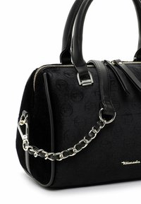 Sac à main noir avec motif de logo circulaire embossé, détail de bandoulière en chaîne argentée, poignées en cuir noir et fermeture éclair.