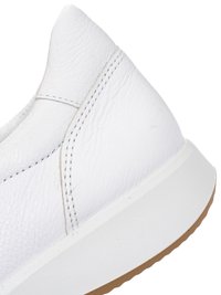 White leather sneaker heel with visible stitching and a thick white sole with a light brown rubber outsole edge.