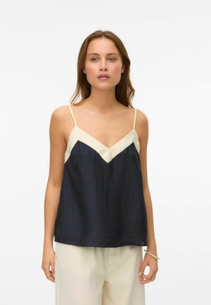 Top camicia in navy con accenti crema, caratterizzato da scollatura a V, spalline sottili e un tessuto testurizzato per una maggiore dimensione.